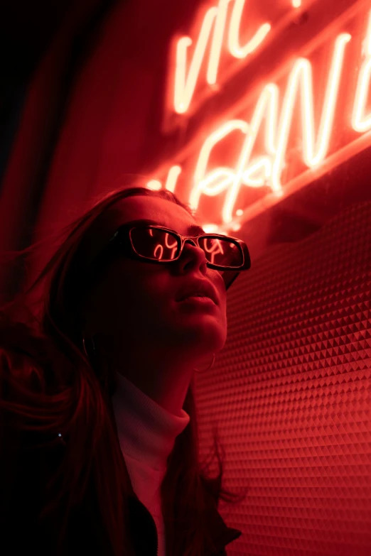 a woman standing in front of a neon sign, trending on pexels, red sunglasses, as she looks up at the ceiling, profile image, pov photo
