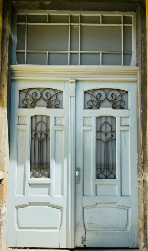 a couple of doors that are next to each other, art nouveau, pale blue, located in hajibektash complex, early 2 0 th century, made of wrought iron