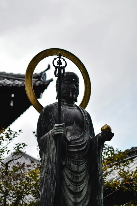 a statue of a person holding a staff, a statue, inspired by Sesshū Tōyō, unsplash, sōsaku hanga, npc with a saint\'s halo, looking towards camera, holding a holy symbol, instagram photo