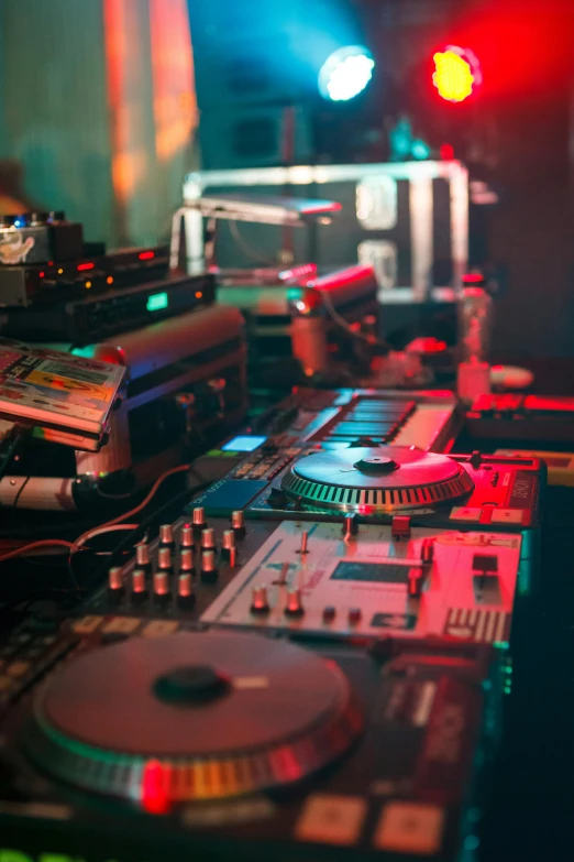 a dj controller sitting on top of a table, multiple stories, radios, nightlife, multicoloured