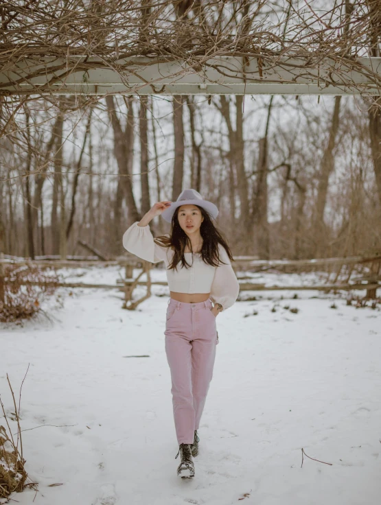 a woman that is standing in the snow, trending on pexels, aestheticism, white and light-pink outfit, wearing farm clothes, cinematic outfit photo, wearing a cropped top