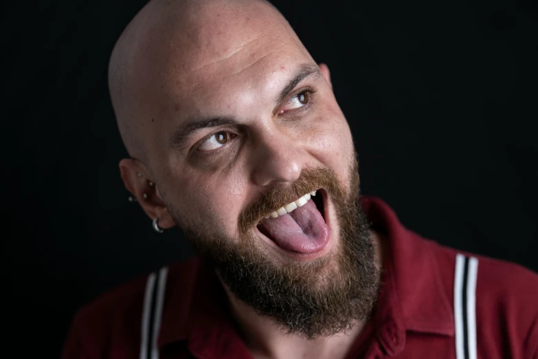 a man with a beard sticking out his tongue, inspired by Volkan Baga, pexels contest winner, hyperrealism, partially bald, smileing nright, aboriginal australian hipster, square masculine jaw