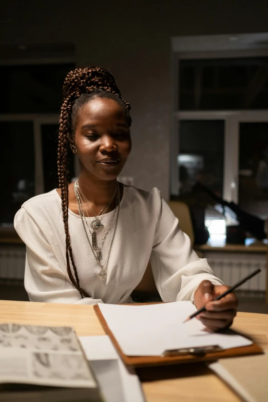 a woman sitting at a table writing on a piece of paper, by Afewerk Tekle, pexels contest winner, academic art, lights on, looking confident, portrait of tall, ( ( dark skin ) )