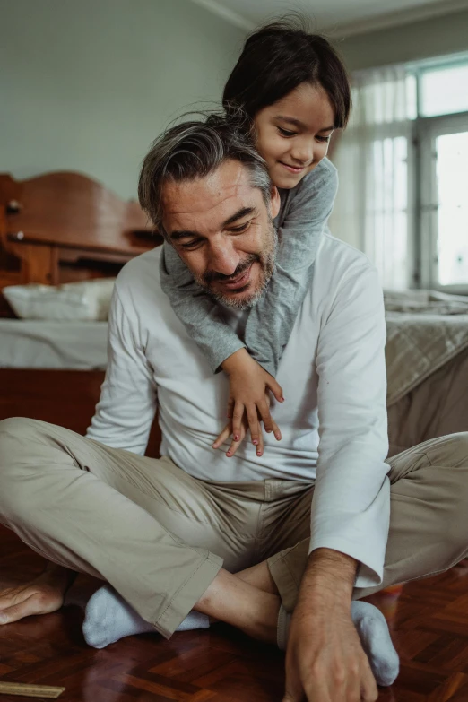 a man and a little girl sitting on the floor, head bent back in laughter, daddy/fatherly, thumbnail, quality