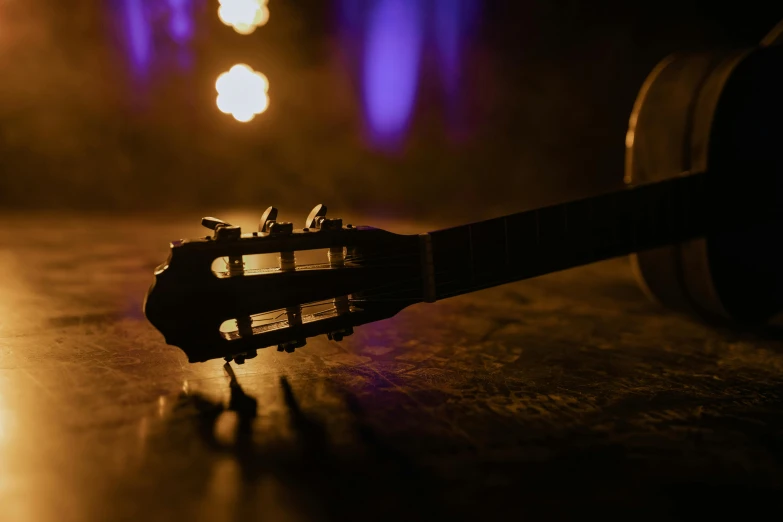 a close up of a guitar on a table, by Niko Henrichon, unsplash, live on stage, lit from behind, promo image, thumbnail