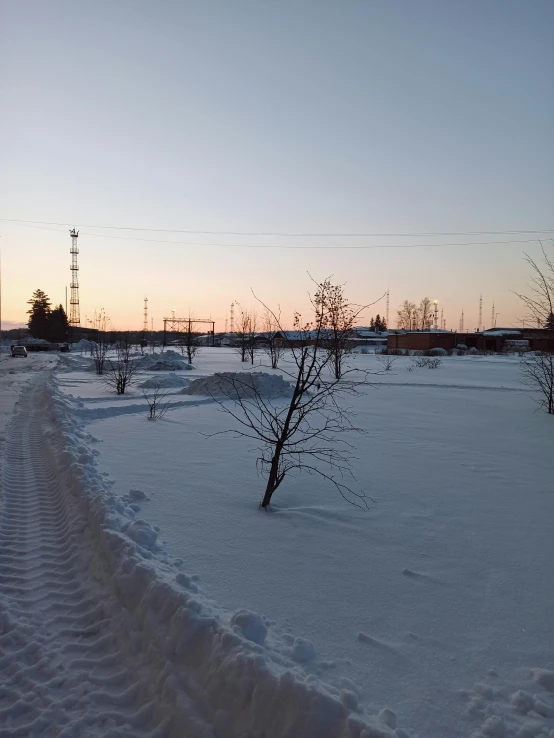 a man riding a snowboard down a snow covered slope, an album cover, inspired by Isaac Levitan, unsplash, land art, walking through a suburb, northern finland, evening at dusk, today\'s featured photograph 4k