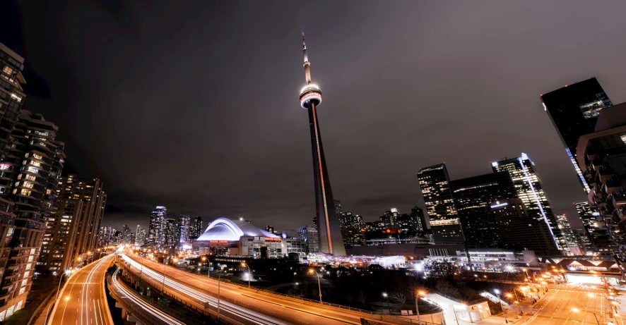 a city street filled with lots of traffic next to tall buildings, pexels contest winner, hurufiyya, cn tower, light show, spire, 4 0 9 6