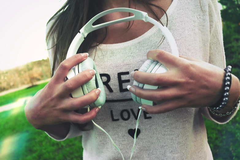 a close up of a person holding a pair of headphones, inspired by Elsa Bleda, aestheticism, wearing a white sweater, picsart, girl in love, sea - green and white clothes