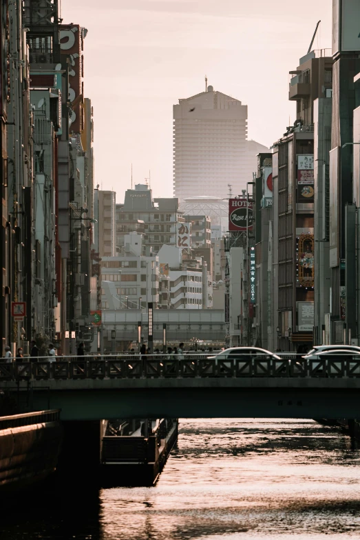 a river running through a city next to tall buildings, unsplash contest winner, ukiyo-e, cinematic morning light, streetscapes, bridges, 2022 photograph