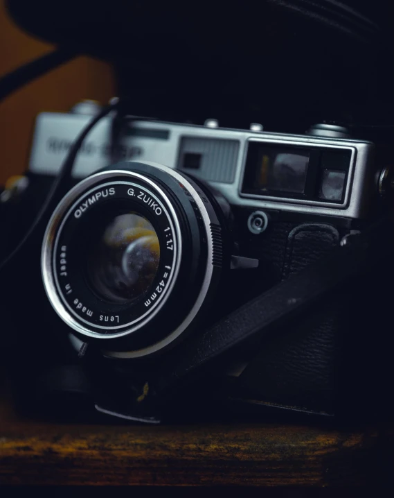 a camera sitting on top of a wooden table, by Adam Marczyński, hasselblad film bokeh, colored photo, vsco, picture