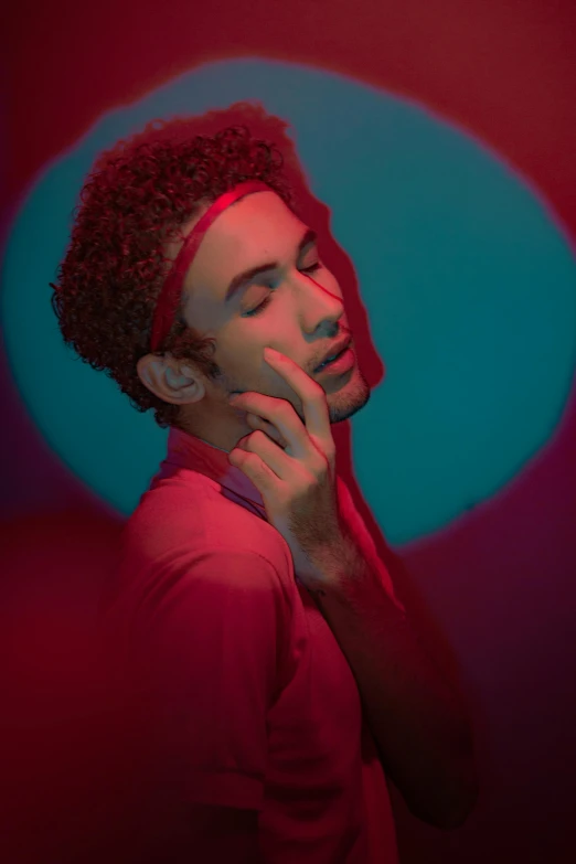 a man in a red shirt talking on a cell phone, an album cover, inspired by Alexis Grimou, trending on pexels, robert sheehan, brown skin man egyptian prince, glowing with colored light, model posing