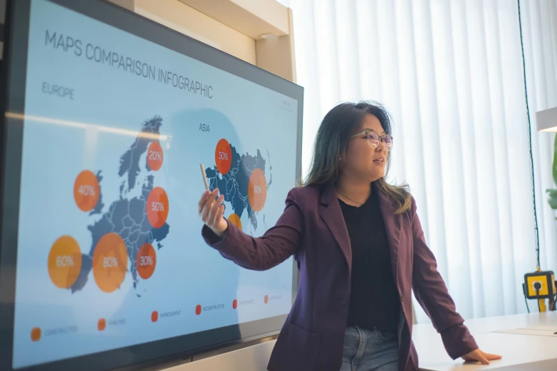 a woman giving a presentation in front of a large screen, trending on unsplash, asian origin, map, 15081959 21121991 01012000 4k, maths