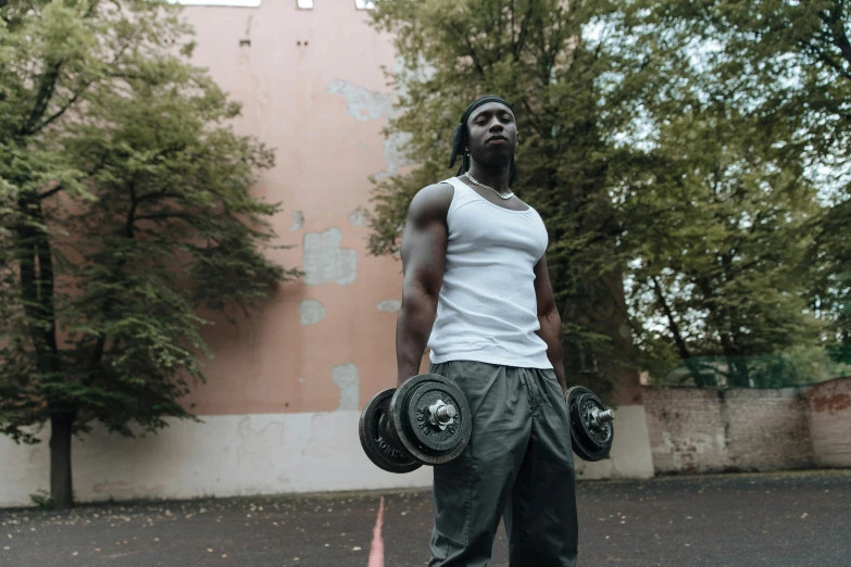 a man standing in a parking lot holding a pair of dumbbells, pexels contest winner, man is with black skin, standing in an alleyway, muscular! white, profile image