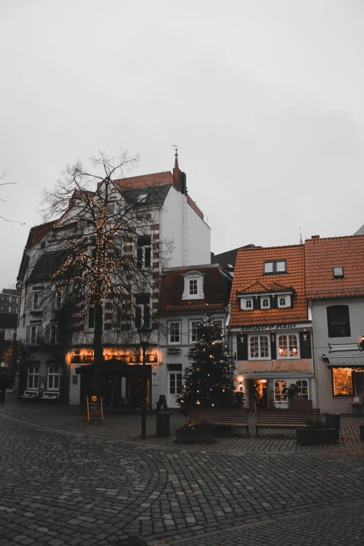 a group of buildings sitting on top of a cobblestone street, christmas, gray and orange colours, square, lower saxony