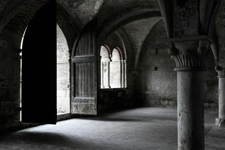 a black and white photo of the inside of a building, an album cover, unsplash contest winner, romanesque, hammershøi, nadav kander, in medieval armoury, crypt