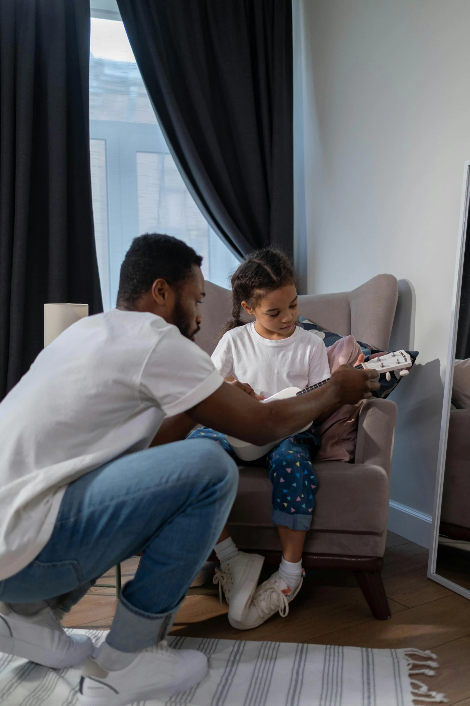 a man and a little girl sitting in front of a tv, playing a guitar, riyahd cassiem, healthcare, gif