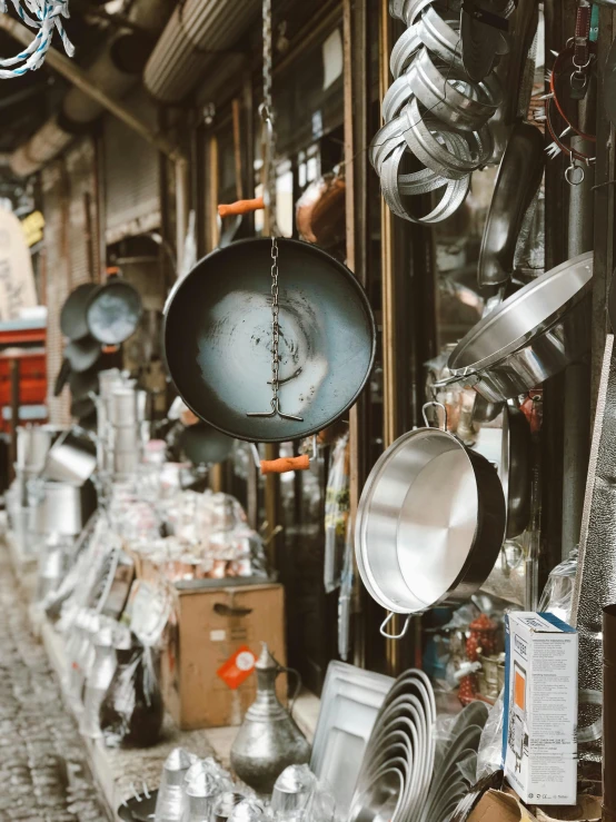 a store filled with lots of pots and pans, trending on unsplash, process art, in the streets of tokyo, thumbnail, sleek metal ears, old kitchen backdrop angled view