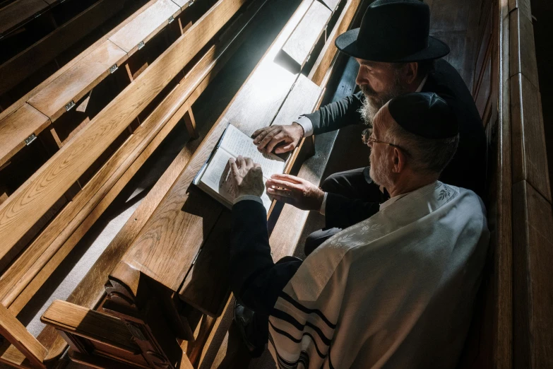 a group of men sitting on top of a wooden bench, mosque synagogue interior, profile image, spotlighting, maintenance