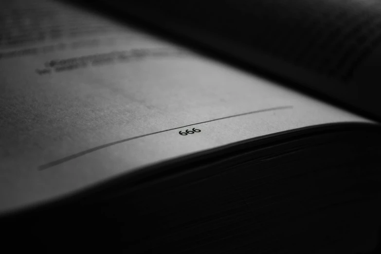 an open book sitting on top of a table, a macro photograph, by Karl Buesgen, unsplash, postminimalism, 6 6 6, minimalistic logo, full page black, close-up!!!!!