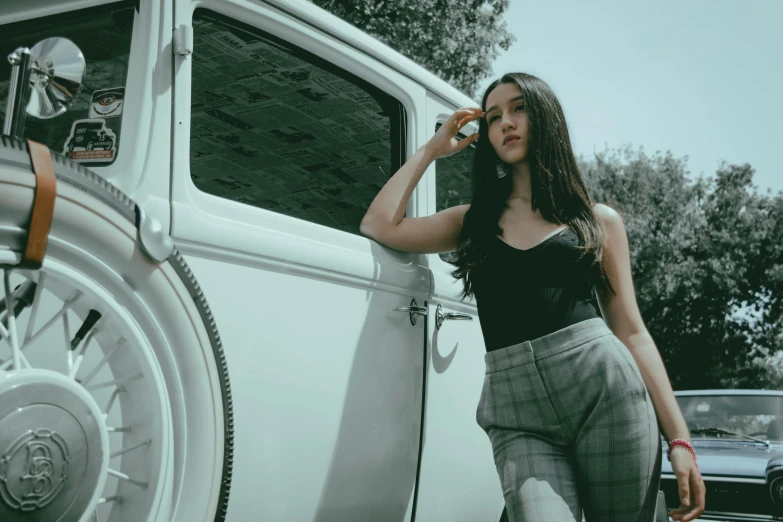 a woman standing next to a car talking on a cell phone, pexels contest winner, photorealism, :: madison beer, truck, mai anh tran, pants