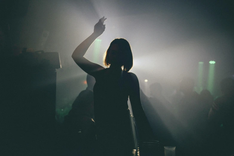 a woman standing in front of a microphone in a dark room, pexels contest winner, happening, dj rave party, raised hand, hazy, severus snape dance in a bar