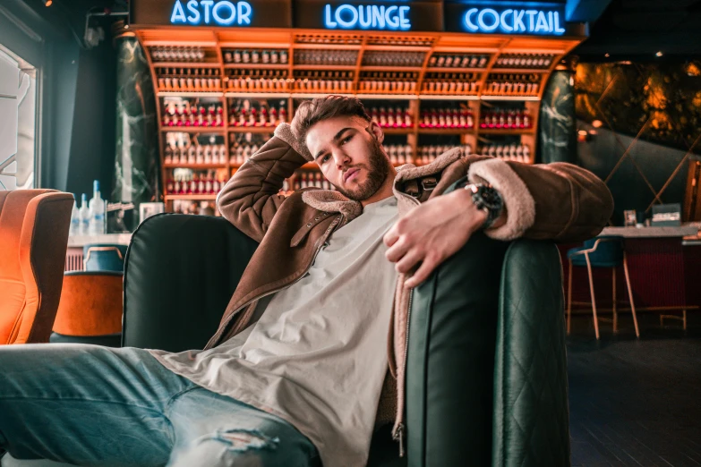 a man sitting in a chair in front of a bar, a portrait, by Julia Pishtar, trending on pexels, zayn malik, astor alexande, attractive pose, avatar image