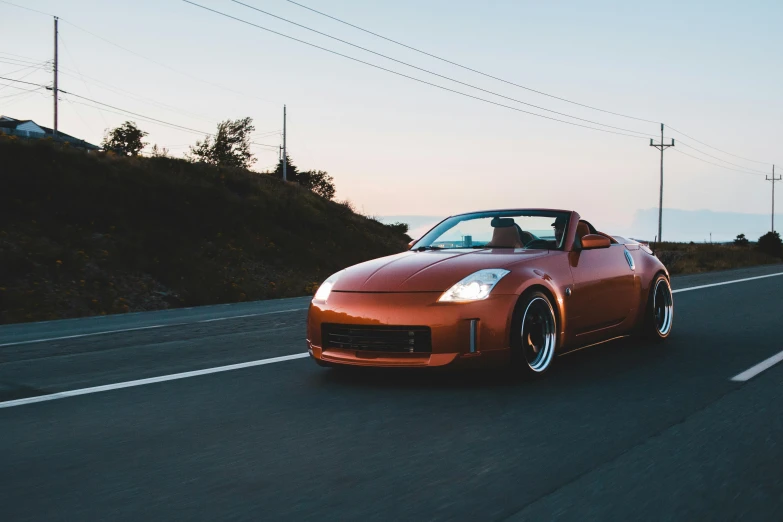 a red sports car driving down the road, unsplash, orange halo, thicc build, samurai vinyl wrap, wide views