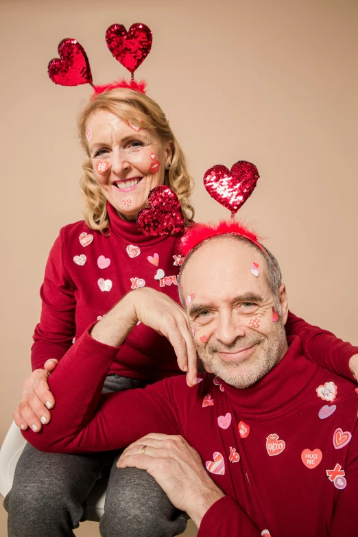 a man and a woman posing for a picture, falling hearts, wearing festive clothing, lynn skordal, head shot