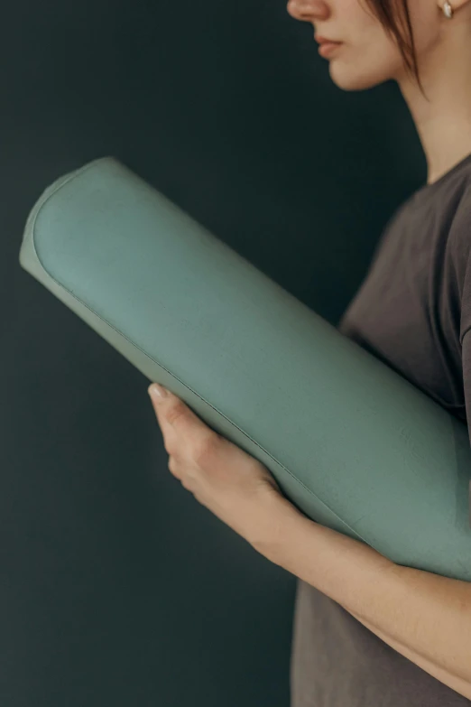 a woman holding a yoga mat in her hands, inspired by Sarah Lucas, trending on unsplash, renaissance, muted green, matte detailed photo, cushions, made of rubber