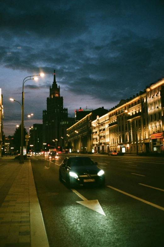 a car driving down a city street at night, pexels contest winner, socialist realism, in moscow centre, with stalinist style highrise, afternoon, 000 — википедия