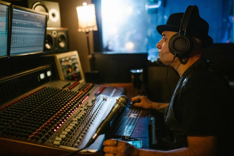 a man wearing headphones sitting in front of a mixing desk, by Lee Loughridge, pexels, process art, tom morello, sydney hanson, avatar image, profile image