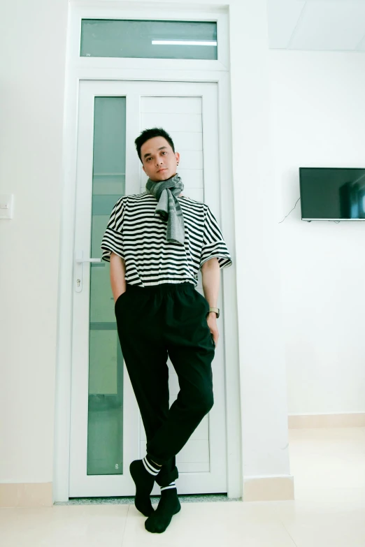 a man standing in front of a white door, instagram, black stripes, androgyny, in style of lam manh, may)