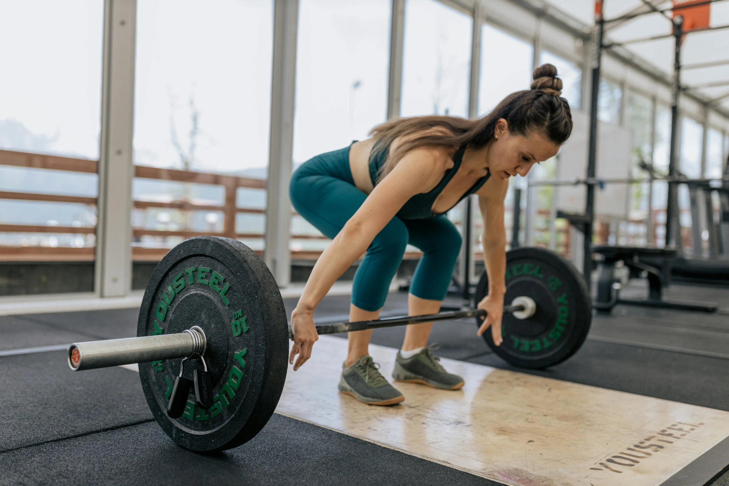 a woman lifting a barbell in a gym, by Emma Andijewska, pexels contest winner, hurufiyya, nature outside, sydney park, bent over, thumbnail