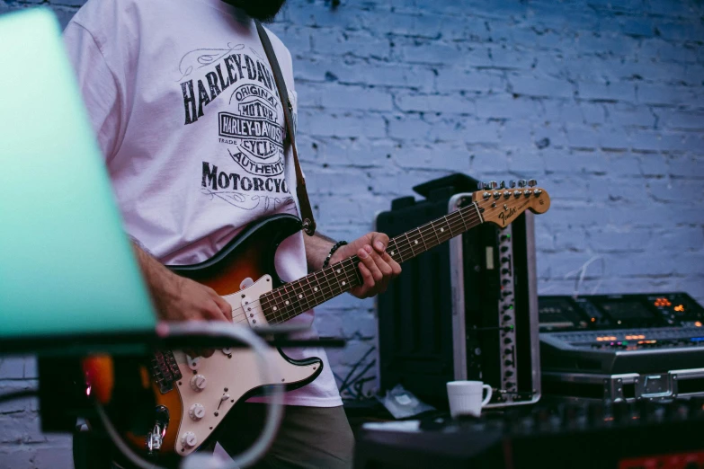 a man with a beard playing a guitar, pexels contest winner, harley davidson motorbike, band merchandise, detailed wide shot, lachlan bailey