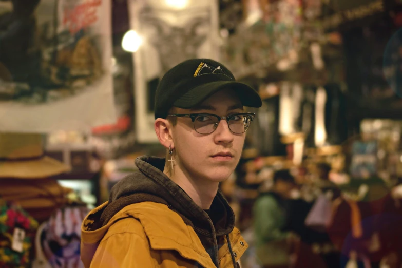a man wearing a hat and glasses in a store, featured on reddit, serial art, portrait androgynous girl, photo taken at night, gauged ears, buzzed hair on temple