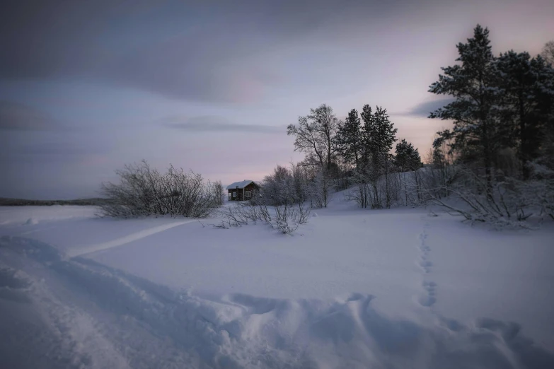 a snow covered field with a house in the distance, a picture, inspired by Einar Hakonarson, pexels contest winner, cliff side at dusk, grey, northern finland, soft lilac skies