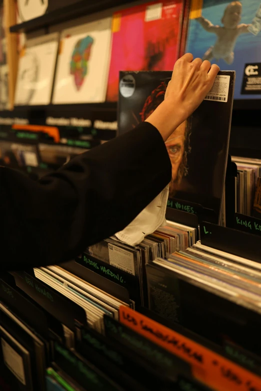 a person reaching for a cd in a record store, an album cover, pexels, happening, sleek spines, thumbnail, stems, shelf