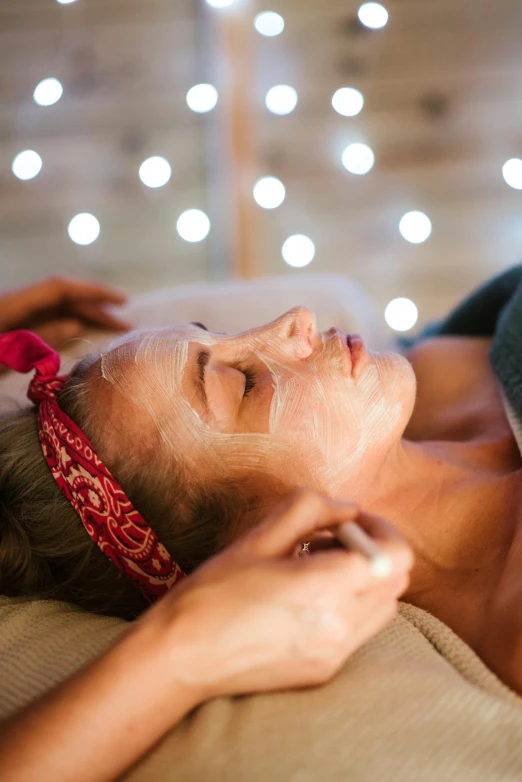 a woman laying on a bed with a sheet on her face, candy treatments, te pae, brightly-lit, manuka