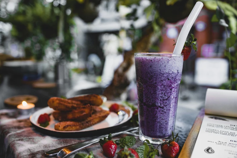 a purple smoothie sitting on top of a table next to a plate of food, by Tom Bonson, pexels, 🦩🪐🐞👩🏻🦳, al fresco, milkshake, ivy's