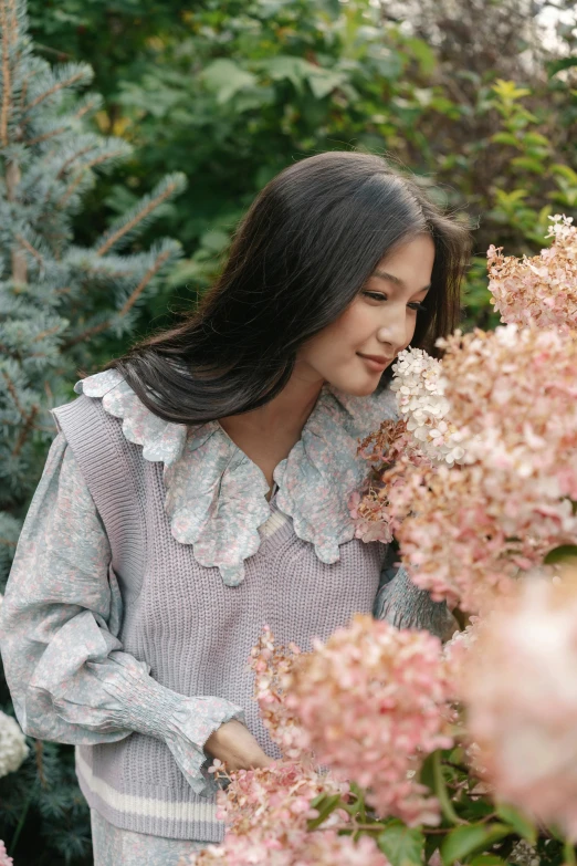 a woman standing next to a bush of flowers, inspired by Kim Jeong-hui, unsplash, long sleeves, bae suzy, frilled blooming collar, portrait image