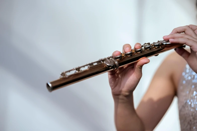 a close up of a person playing a flute, unsplash, photorealism, shiny metal, on a pale background, slide show, very thin