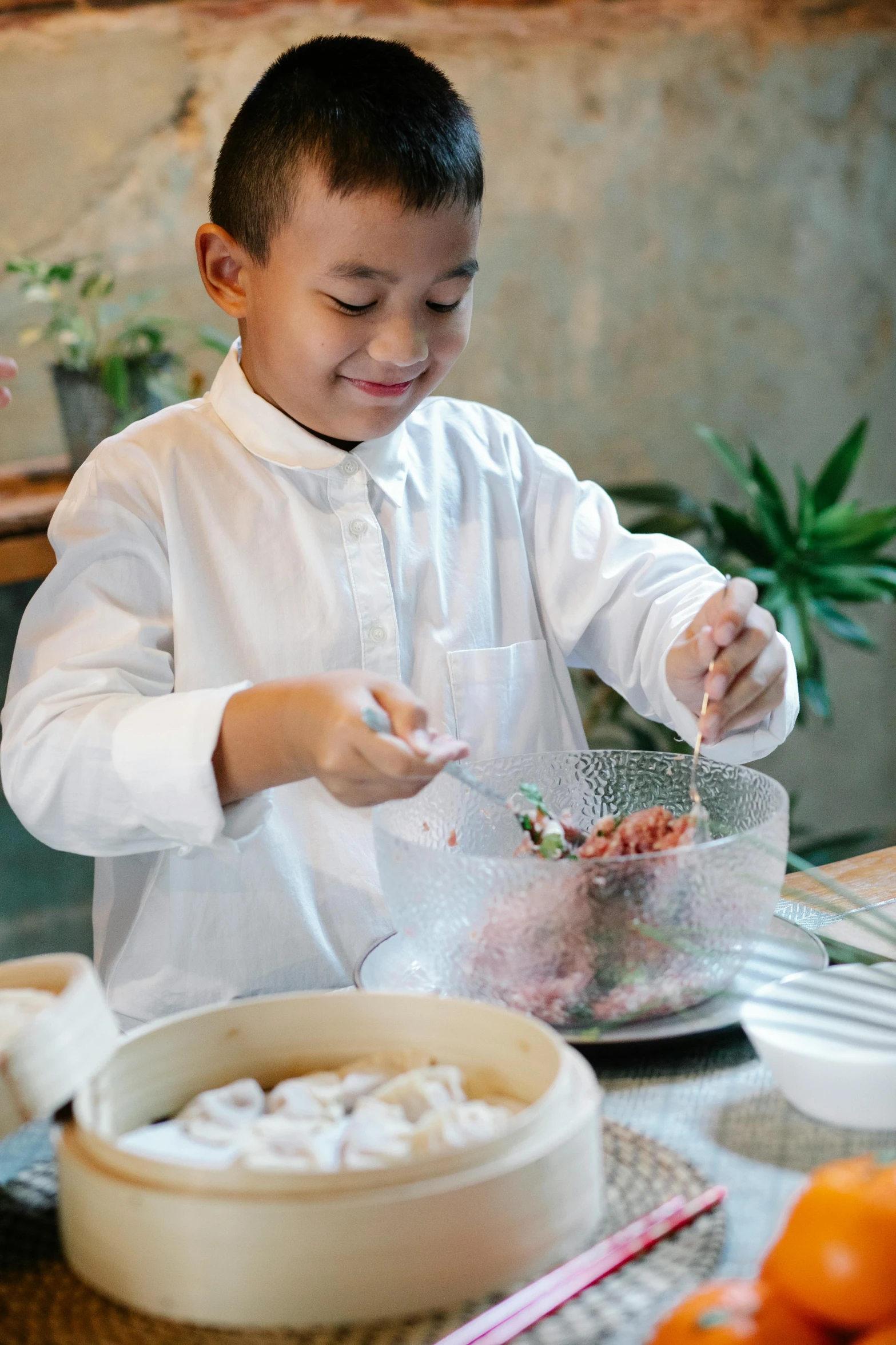 a little boy that is sitting at a table, inspired by Cui Bai, unsplash, cooking it up, barong family, medium close up shot, hanging