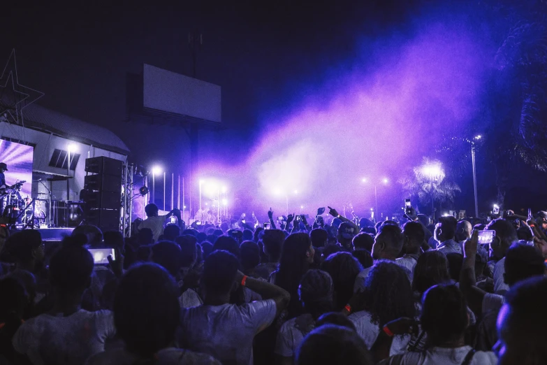 a crowd of people standing in front of a stage, pexels contest winner, purple and blue neon, rex orange county, night outside, slight haze