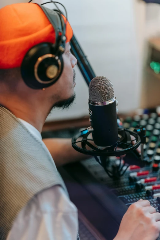 a man wearing headphones sitting in front of a microphone