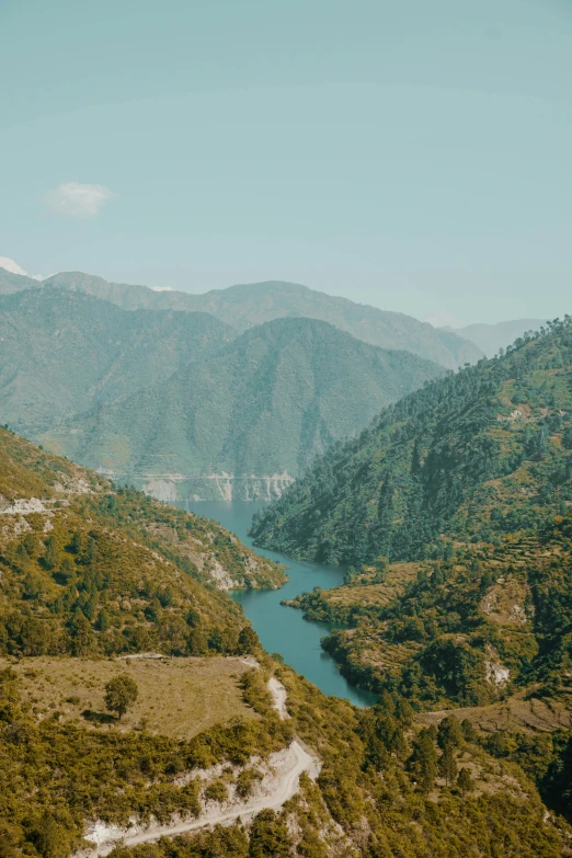 a river running through a lush green valley, by Muggur, pexels contest winner, les nabis, uttarakhand, lake view, panoramic view, teal color graded