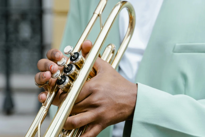 a close up of a person holding a trumpet, wearing a light blue suit, muzinabu, brass plated, zoomed in