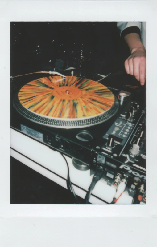 a close up of a person playing a record on a turntable, by Pablo Rey, kinetic pointillism, disposable camera photograph, multi - coloured, 1999 photograph, dj set