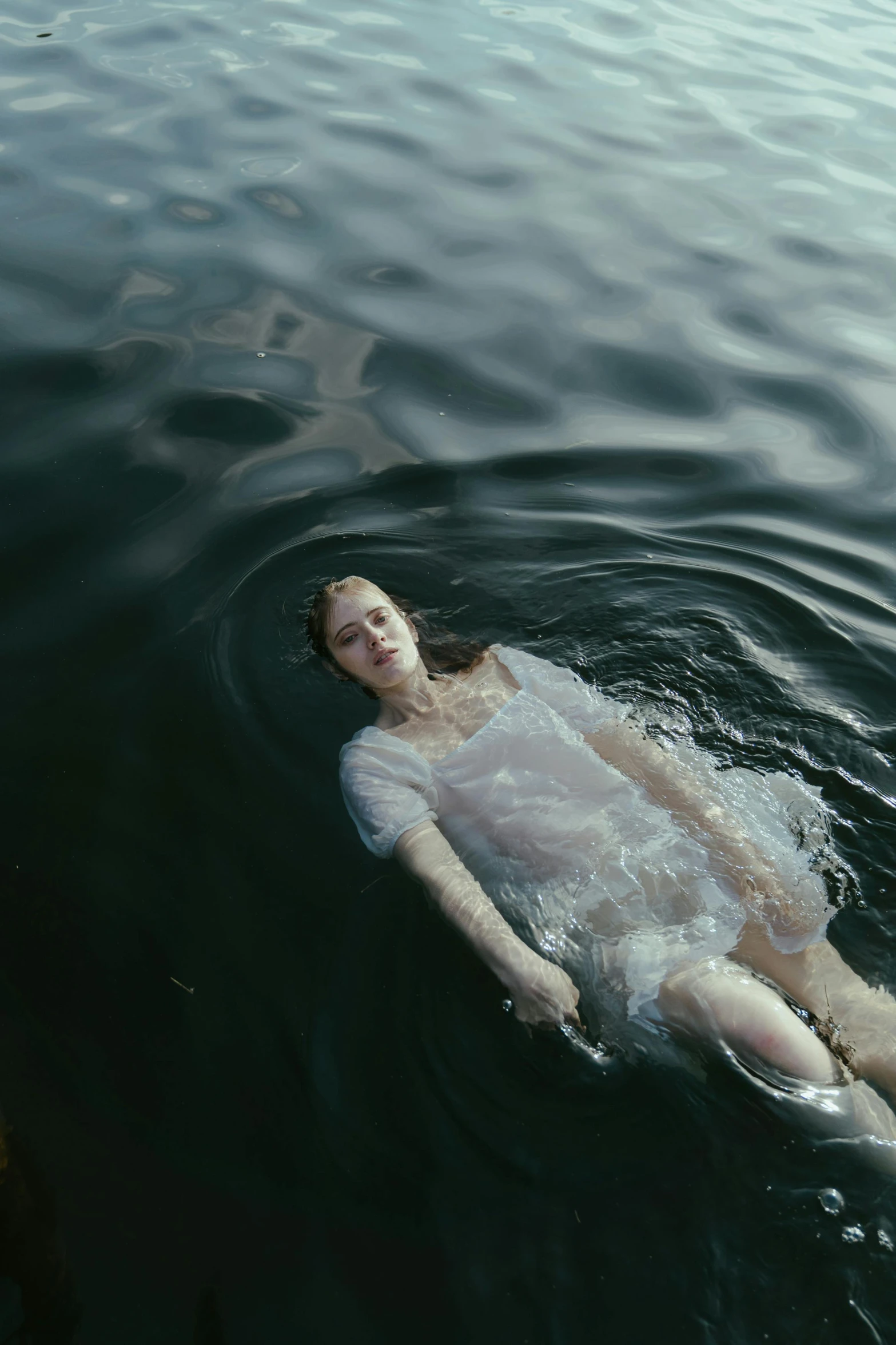 a woman floating on top of a body of water, a picture, inspired by Elsa Bleda, unsplash contest winner, renaissance, extremely pale white skin, teenage girl, ignant, currents