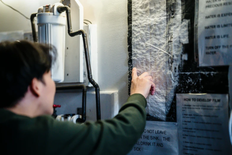 a man standing in front of a water heater, a silk screen, inspired by Ian Hamilton Finlay, pexels contest winner, interactive art, cracking glass through reality, texture detail, people at work, white tracing