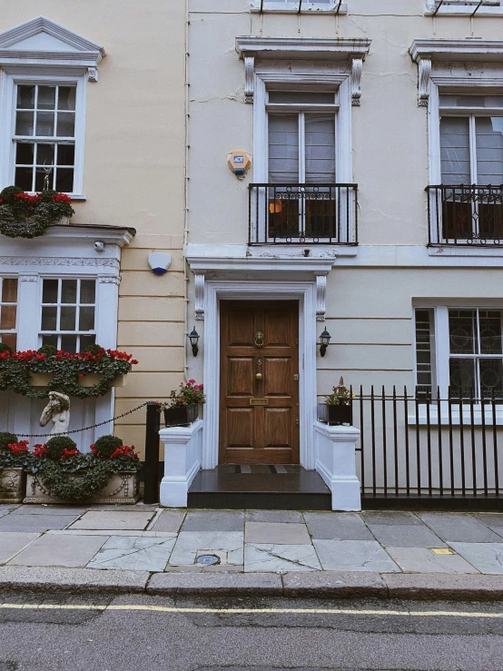 a couple of buildings that are next to each other, by Adam Rex, pexels contest winner, neoclassicism, doors to various living quarters, flowers around, professional iphone photo